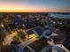 An aerial view of a neighborhood at dusk, highlighting a home with a screened-in pool and neat landscaping at 513 Manns Harbor Dr, Apollo Beach, FL 33572
