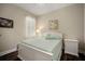 Bright bedroom features a white bed frame, hardwood floors, and natural light from window at 513 Manns Harbor Dr, Apollo Beach, FL 33572