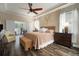 Comfortable main bedroom features a ceiling fan, wood floors, and a connecting room for work or relaxation at 513 Manns Harbor Dr, Apollo Beach, FL 33572