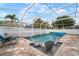 A pristine screened-in pool area, perfect for relaxation and entertaining, with lush landscaping views at 513 Manns Harbor Dr, Apollo Beach, FL 33572