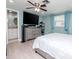 Spacious bedroom with blue walls, a ceiling fan, a TV, an ensuite bathroom, and wood-look flooring at 5433 Palmetto Rd, New Port Richey, FL 34652