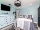 Inviting bedroom with light blue walls, wood-look flooring, lots of natural light, and a large dresser at 5433 Palmetto Rd, New Port Richey, FL 34652