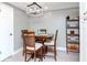 Dining room with light gray walls, wood flooring, and an elegant, modern chandelier above a wood table at 5433 Palmetto Rd, New Port Richey, FL 34652