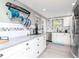 Bright, updated kitchen with white cabinets, stainless steel appliances, and a hanging pot rack at 5433 Palmetto Rd, New Port Richey, FL 34652