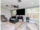 Modern living room featuring a large flat-screen TV, ceiling fan, and comfortable seating arrangement at 5433 Palmetto Rd, New Port Richey, FL 34652