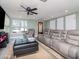 Bright living room with a comfortable gray sectional, a stylish ottoman, and ample natural light through large windows at 5433 Palmetto Rd, New Port Richey, FL 34652