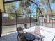 The outdoor dining setup on the screened in patio creates a relaxing area to enjoy the view at 5433 Palmetto Rd, New Port Richey, FL 34652