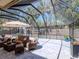 A screened patio features brick pavers, a seating area, and views of the beautiful surrounding nature at 5433 Palmetto Rd, New Port Richey, FL 34652