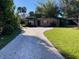 Charming brick home features a paved driveway, mature trees, and well-maintained landscaping at 5706 River Terrace, Tampa, FL 33604