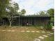 Exterior view of home featuring a screened-in porch, established landscaping and backyard area at 5706 River Terrace, Tampa, FL 33604
