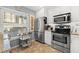 Bright kitchen featuring white cabinets, stainless steel appliances, and granite countertops at 6140 Sun Blvd # 5, St Petersburg, FL 33715
