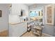 Bright kitchen with white cabinets, granite countertops, and a table near the window at 6140 Sun Blvd # 5, St Petersburg, FL 33715
