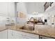 Close-up of a kitchen with granite countertops, stainless steel sink, and white cabinetry at 6140 Sun Blvd # 5, St Petersburg, FL 33715