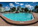 Large community pool surrounded by palm trees and multiple condominium buildings at 6201 2Nd E St # 89, St Pete Beach, FL 33706