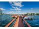 View down a wooden dock leading to a boat on the water under a blue sky with scattered clouds at 6201 2Nd E St # 89, St Pete Beach, FL 33706