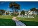 Landscaped grounds with green grass, tall palm trees, shuffleboard courts, and a brick walkway at 6201 2Nd E St # 89, St Pete Beach, FL 33706