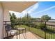 Private balcony with wrought iron railing and outdoor seating, overlooking a serene backyard at 720 Lyndhurst St # 1121, Dunedin, FL 34698