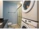 Bright bathroom with a modern glass shower and convenient stacked washer and dryer at 720 Lyndhurst St # 1121, Dunedin, FL 34698