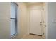 Bright hallway with neutral walls, tile flooring, and a window providing natural light at 720 Lyndhurst St # 1121, Dunedin, FL 34698
