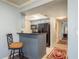 Modern kitchen with sleek breakfast bar, dark granite countertops, and stainless steel appliances at 720 Lyndhurst St # 1121, Dunedin, FL 34698