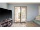 Living room view with a TV, French doors, and cozy seating, perfect for relaxation at 720 Lyndhurst St # 1121, Dunedin, FL 34698