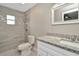Updated bathroom with tiled shower, modern fixtures, and granite countertop vanity at 7323 Andre Dr, Zephyrhills, FL 33541
