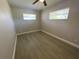 This is a bright bedroom featuring gray vinyl floors, two windows, and neutral paint at 7323 Andre Dr, Zephyrhills, FL 33541