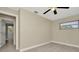 Bright bedroom features neutral walls, light wood floor, window, and ceiling fan at 7323 Andre Dr, Zephyrhills, FL 33541