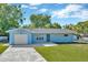 Charming single-story home featuring a well-manicured lawn and a spacious driveway leading to an attached garage at 7323 Andre Dr, Zephyrhills, FL 33541