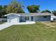 Charming single-story home with a well-manicured lawn, attached garage, and neutral-colored exterior at 7323 Andre Dr, Zephyrhills, FL 33541