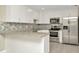 Updated kitchen with white cabinets, stainless steel appliances, and granite countertops at 7323 Andre Dr, Zephyrhills, FL 33541
