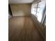 Well-lit living room with wood-look flooring and a bright window at 7735 Gaston Dr, Port Richey, FL 34668