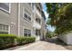 Three-story building featuring private balconies with white railings and lush landscaping at 800 S Dakota Ave # 221, Tampa, FL 33606
