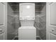 Laundry closet includes a stacked washer and dryer surrounded by wire shelving for organized storage at 800 S Dakota Ave # 221, Tampa, FL 33606