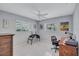 Bedroom with desk and chair, ceiling fan and two windows with blinds, showcasing bright light at 8243 37Th N Ave, St Petersburg, FL 33710