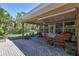 Relaxing covered patio featuring brick pavers, lush backyard views, and neutral-toned chairs at 8243 37Th N Ave, St Petersburg, FL 33710