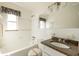 Bright bathroom featuring a large mirror, granite countertop, and white tiled walls at 88 45Th Ave, St Pete Beach, FL 33706