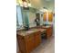Well-lit bathroom with dual vanities, granite counters, and decorative fixtures at 8910 Eagle Watch Dr, Riverview, FL 33578