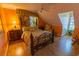 Cozy bedroom features a decorative metal bed frame, hardwood floors, and bright orange walls at 8910 Eagle Watch Dr, Riverview, FL 33578