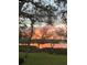 Scenic lake view with a vibrant sunset reflecting on the water, framed by mature trees at 8910 Eagle Watch Dr, Riverview, FL 33578