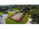 Aerial shot showcases a private tennis court, surrounded by lush greenery and elegant landscaping at 8910 Eagle Watch Dr, Riverview, FL 33578