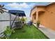Charming front porch with artificial turf, a porch swing, and comfortable outdoor seating at 9122 Suffield Ct, Tampa, FL 33615