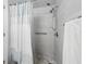 Modern shower with gray tiled walls, updated showerhead, and mosaic tile accent border at 9122 Suffield Ct, Tampa, FL 33615