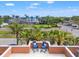 Relaxing balcony view featuring comfortable chairs, vibrant palm trees, and scenic water views beyond at 920 N Shore Ne Dr, St Petersburg, FL 33701