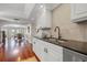 Modern kitchen with black granite countertops, white cabinets, stainless dishwasher, and wood floors at 920 N Shore Ne Dr, St Petersburg, FL 33701