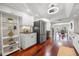 Bright kitchen boasts white cabinets, stainless fridge, dark countertops, and rich hardwood floors at 920 N Shore Ne Dr, St Petersburg, FL 33701