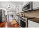 Modern kitchen with white cabinets, stainless steel appliances, and wood floors overlooking the dining area at 920 N Shore Ne Dr, St Petersburg, FL 33701