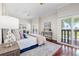 Bright main bedroom featuring hardwood floors, ceiling fan, and sliding glass doors leading to a private balcony at 920 N Shore Ne Dr, St Petersburg, FL 33701