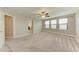 Spacious carpeted bedroom featuring neutral colors, bright windows, and a ceiling fan at 9917 Ivory Dr, Ruskin, FL 33573