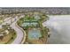 Aerial view showcasing community amenities, including pools, tennis courts, and basketball court by the lake at 9917 Ivory Dr, Ruskin, FL 33573